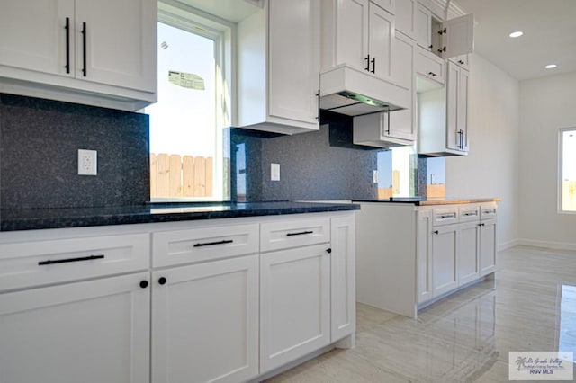 kitchen with white cabinetry, custom range hood, recessed lighting, and tasteful backsplash