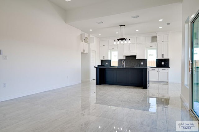 kitchen with dark countertops, decorative backsplash, white cabinets, and baseboards