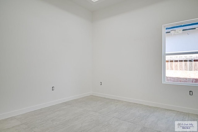 unfurnished room with baseboards