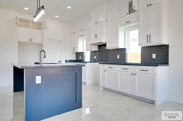 kitchen with tasteful backsplash, hanging light fixtures, and white cabinetry