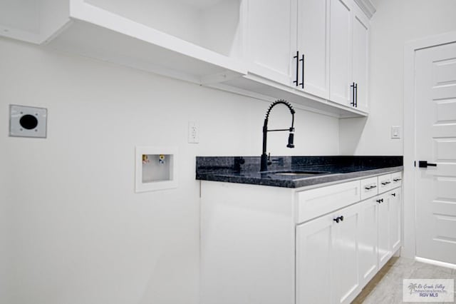 washroom with a sink, cabinet space, hookup for an electric dryer, and washer hookup