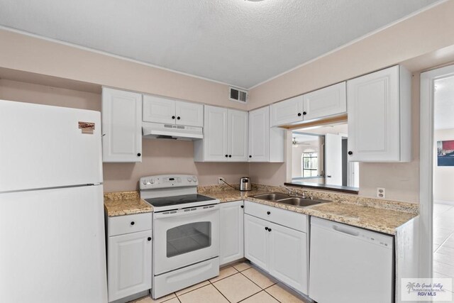 kitchen featuring white cabinetry, sink, a textured ceiling, white appliances, and light tile patterned floors