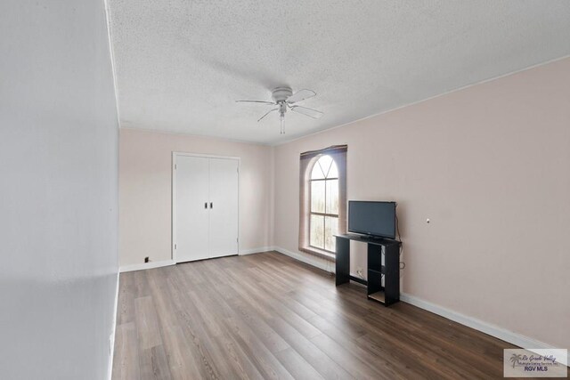 unfurnished living room with a textured ceiling, hardwood / wood-style flooring, and ceiling fan