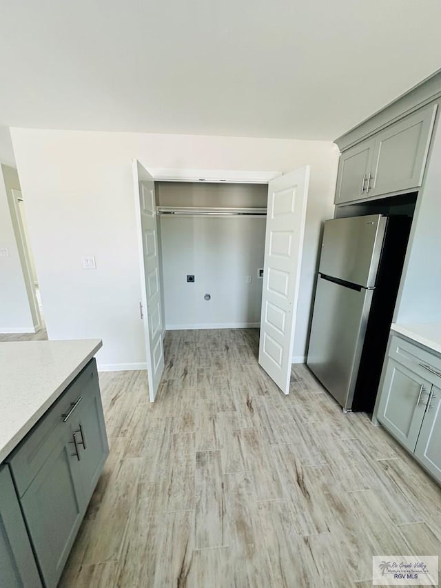 kitchen with light hardwood / wood-style floors and stainless steel refrigerator