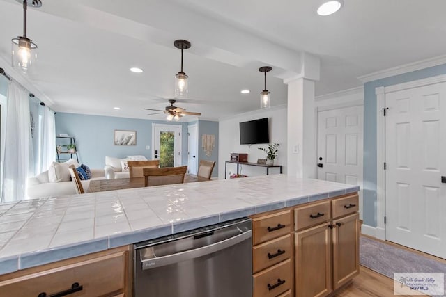 kitchen featuring light wood-style flooring, open floor plan, tile countertops, crown molding, and dishwasher