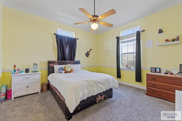 carpeted bedroom with ceiling fan, ornamental molding, and a textured ceiling