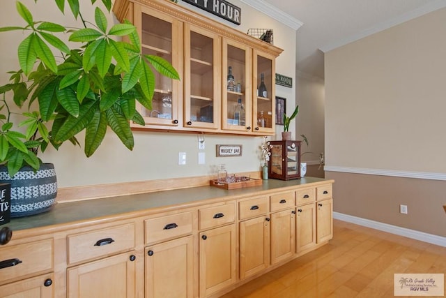 kitchen with glass insert cabinets, light brown cabinetry, and crown molding