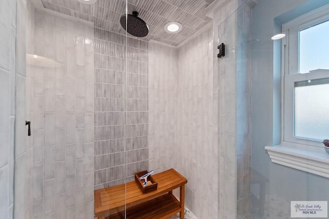 full bath featuring plenty of natural light and tiled shower