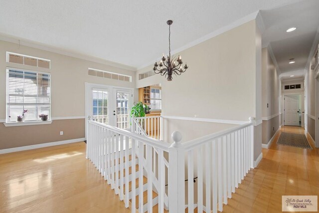 corridor with crown molding, an upstairs landing, visible vents, and baseboards