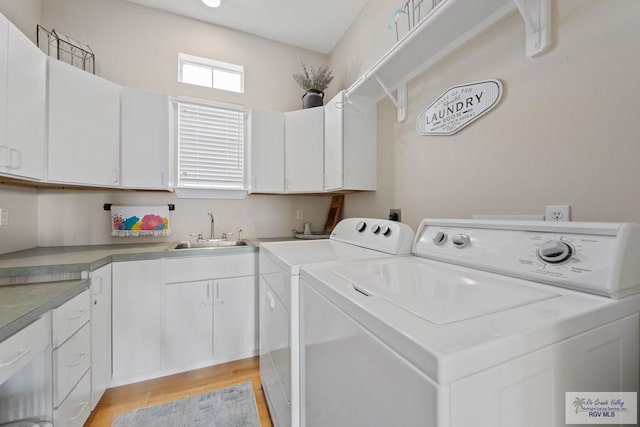 washroom with washer and clothes dryer, cabinet space, light wood-style floors, and a sink