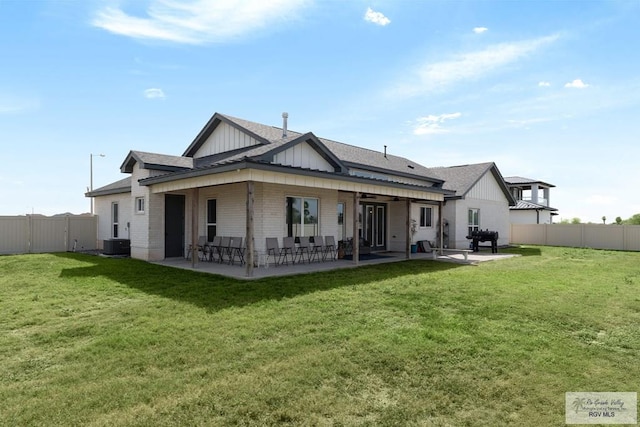 1709 Thacker Ln, Harlingen, TX 78552 - back of property featuring board and batten siding, a patio area, a fenced backyard, and a lawn