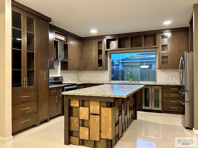 kitchen with a kitchen island, beverage cooler, light stone counters, stainless steel appliances, and dark brown cabinets