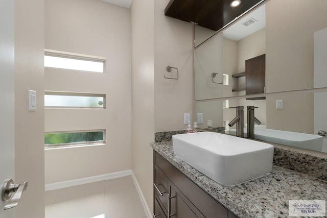 bathroom with plenty of natural light, tile patterned flooring, and vanity