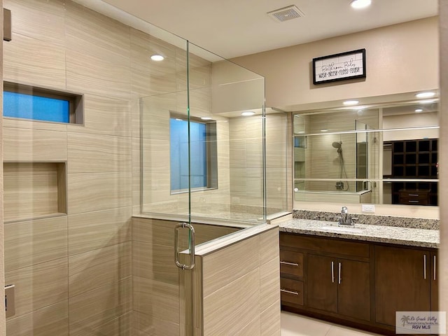 bathroom with vanity, tile patterned floors, and a shower with shower door