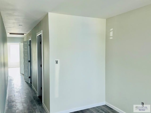 hallway with baseboards and dark wood finished floors