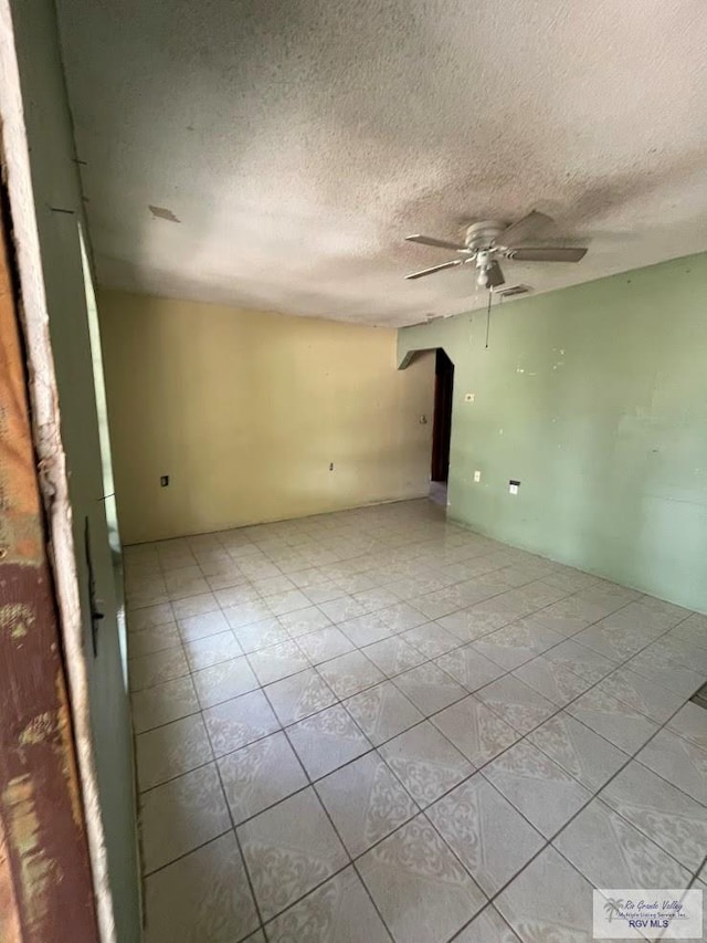 empty room featuring a textured ceiling and ceiling fan