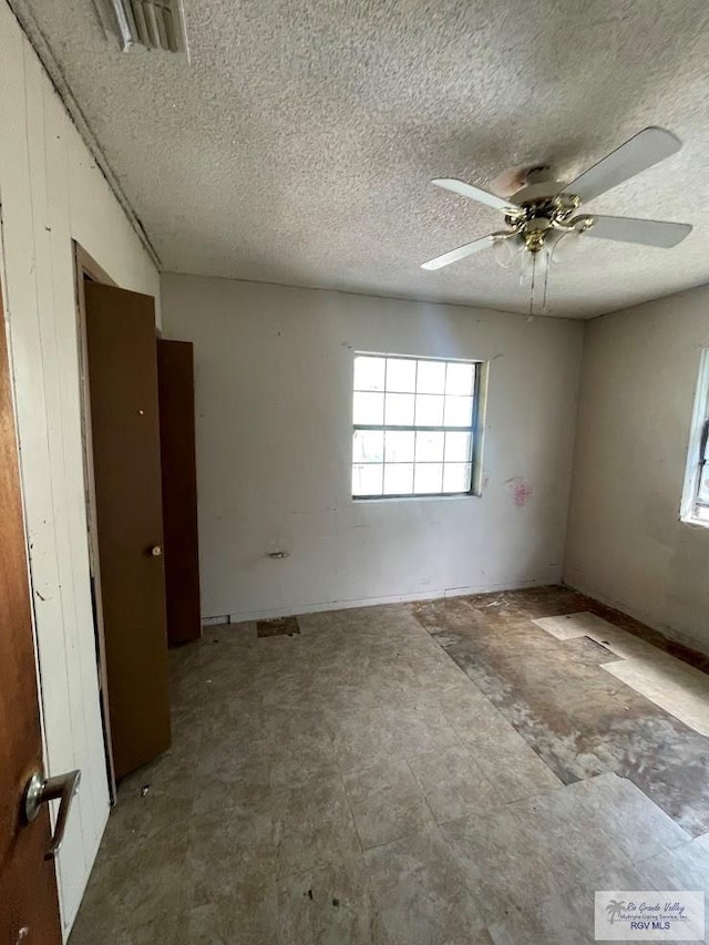 spare room with a textured ceiling and ceiling fan