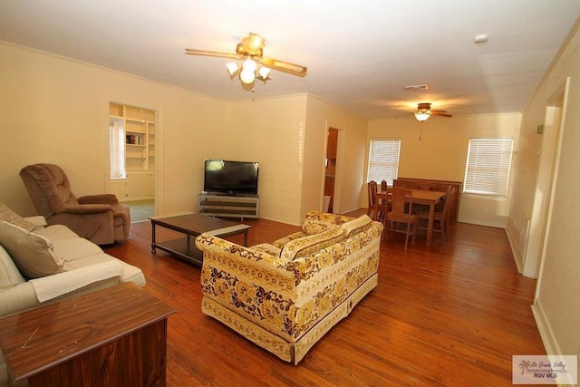 living room with a ceiling fan, wood finished floors, and baseboards