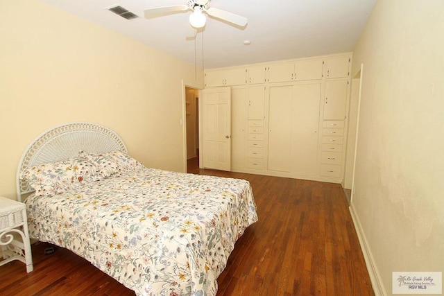 bedroom featuring dark wood-style flooring, baseboards, a closet, and a ceiling fan