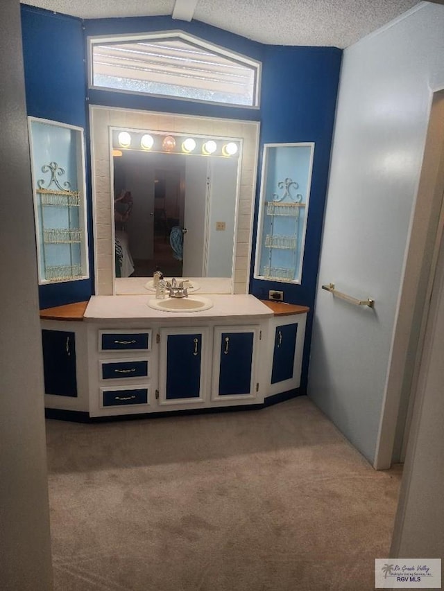 bathroom featuring lofted ceiling with beams, a textured ceiling, and vanity