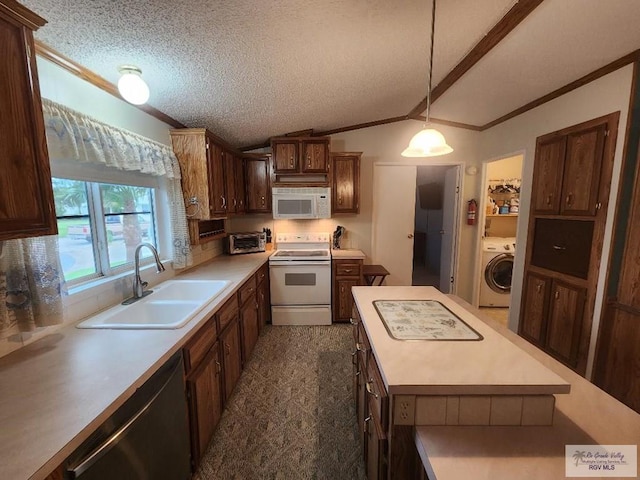 kitchen featuring white appliances, vaulted ceiling, sink, washer / clothes dryer, and hanging light fixtures