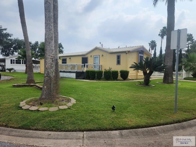 view of front of property featuring a front lawn and a deck