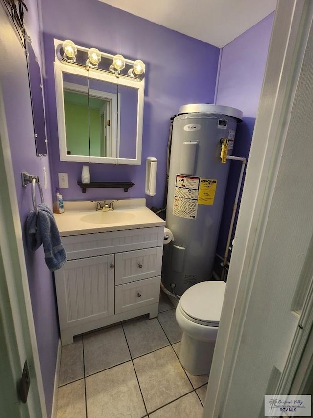 bathroom featuring tile patterned flooring, vanity, toilet, and water heater