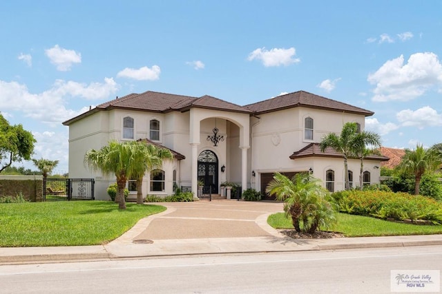 mediterranean / spanish-style home featuring a garage and a front lawn