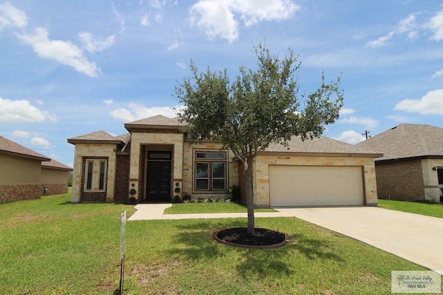 814 Knotty Pine Ln, Harlingen, TX 78552 - prairie-style house with a garage, concrete driveway, a front lawn, and stone siding