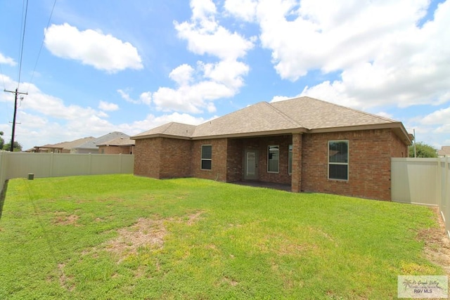 814 Knotty Pine Ln, Harlingen, TX 78552 - rear view of property with a fenced backyard, brick siding, and roof with shingles