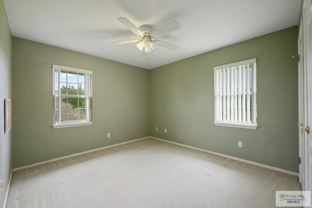 carpeted spare room featuring ceiling fan