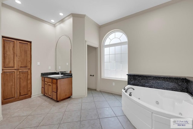 bathroom with tile patterned floors, vanity, a jetted tub, and crown molding