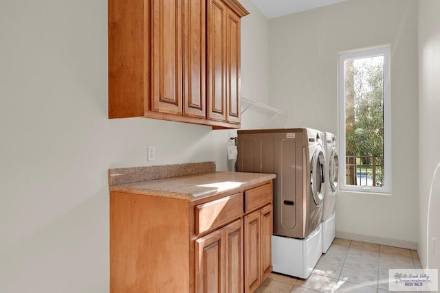 laundry room featuring cabinet space, washing machine and dryer, baseboards, and a wealth of natural light