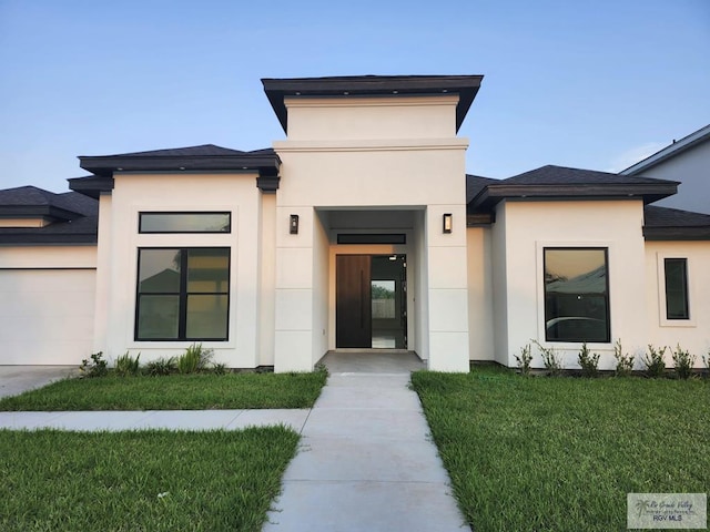 1321 White Oak Dr, Harlingen, TX 78522 - view of front of home with an attached garage, a front yard, stucco siding, and concrete driveway