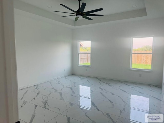 1321 White Oak Dr, Harlingen, TX 78522 - spare room featuring a tray ceiling, baseboards, a ceiling fan, light marble finish flooring, and recessed lighting