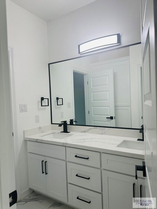 1321 White Oak Dr, Harlingen, TX 78522 - bathroom featuring marble finish floors, double vanity, and baseboards