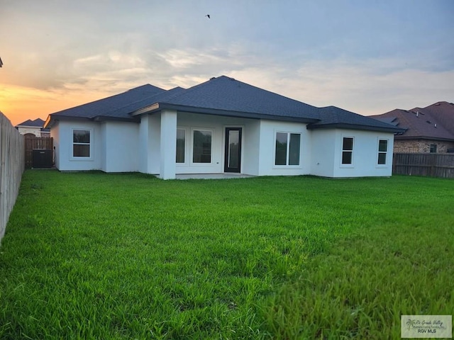 1321 White Oak Dr, Harlingen, TX 78522 - back of house featuring stucco siding, cooling unit, and roof with shingles
