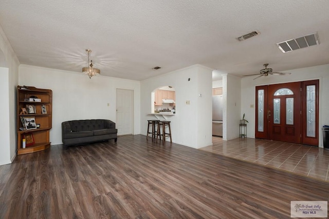 foyer with ceiling fan, dark wood-type flooring, and a textured ceiling