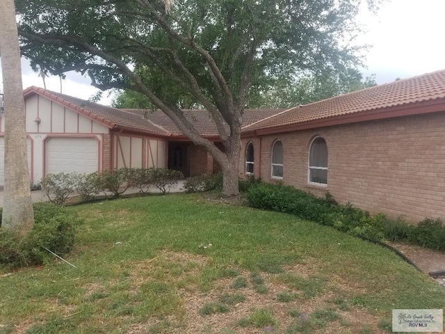 view of front of property featuring a front lawn and a garage