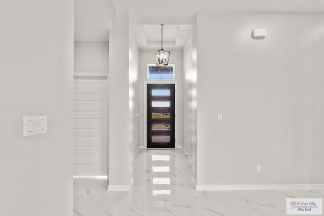 foyer entrance featuring a notable chandelier