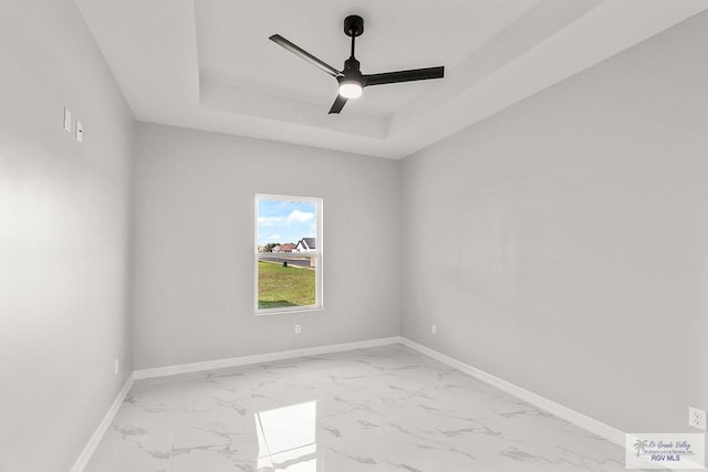 empty room with a tray ceiling and ceiling fan