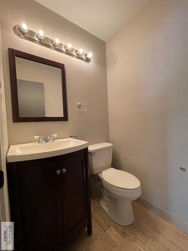 bathroom with vanity, hardwood / wood-style flooring, and toilet