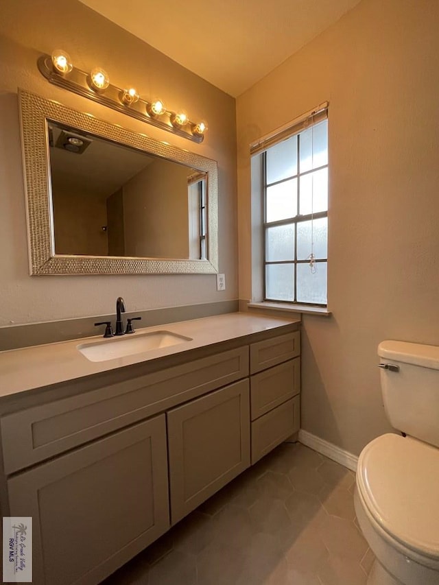 bathroom featuring tile patterned flooring, vanity, and toilet