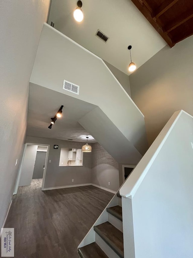 stairway with hardwood / wood-style flooring and vaulted ceiling