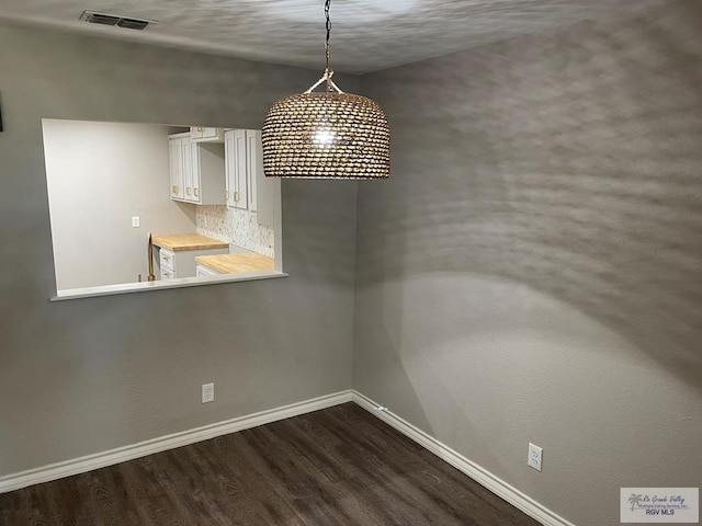 unfurnished dining area featuring dark hardwood / wood-style flooring