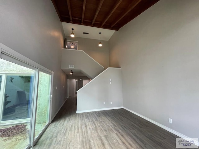 unfurnished living room featuring dark hardwood / wood-style flooring, wooden ceiling, and high vaulted ceiling