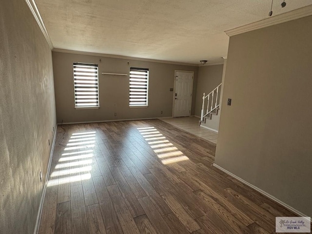 unfurnished room with hardwood / wood-style flooring, crown molding, and a textured ceiling