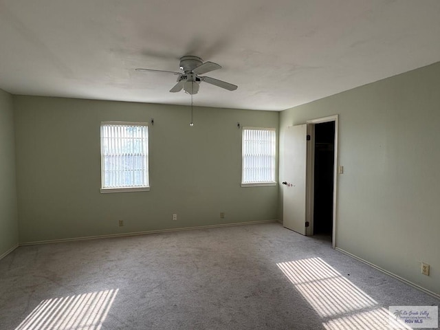 empty room with ceiling fan and light carpet