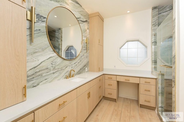 bathroom with tasteful backsplash, vanity, wood-type flooring, and a shower with shower door