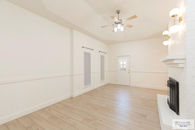 unfurnished living room with light hardwood / wood-style flooring, a fireplace, and ceiling fan